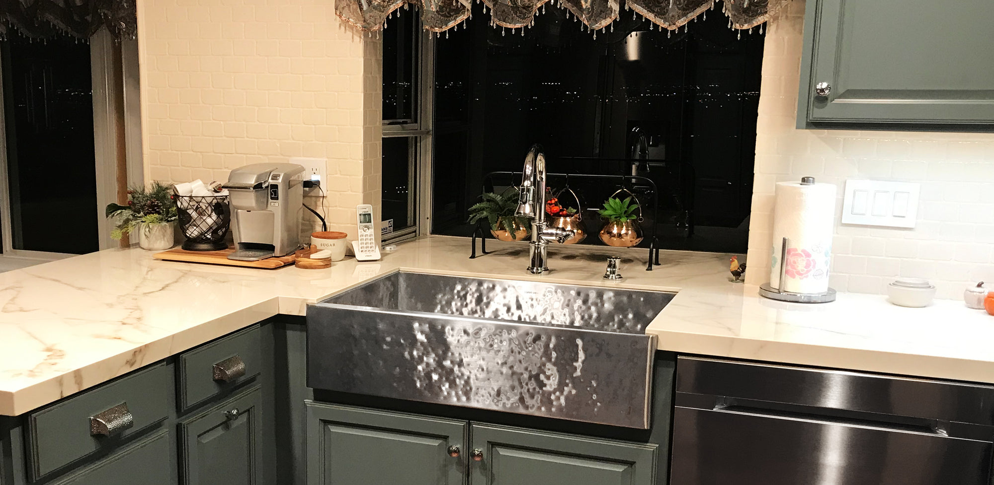 Hammered stainless steel farmhouse sink USA made by Havens Luxury Metals. White countertops made from natural stone with a heavy hammered finish. Custom made 
