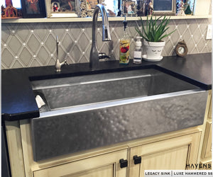 Matte hammered stainless steel farmhouse sink with a rustic appearance. Culinary workstation style sink with a built in ledge for accessories. 