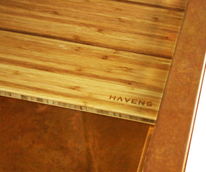 Cutting board on a copper kitchen farmhouse sink.